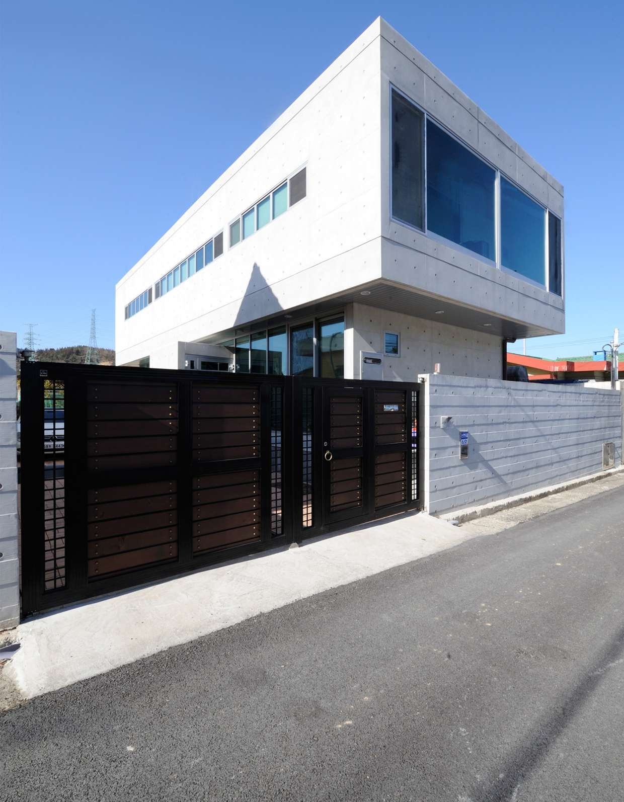 Completed house with a cantilevered glazed corner over a street-level entrance
